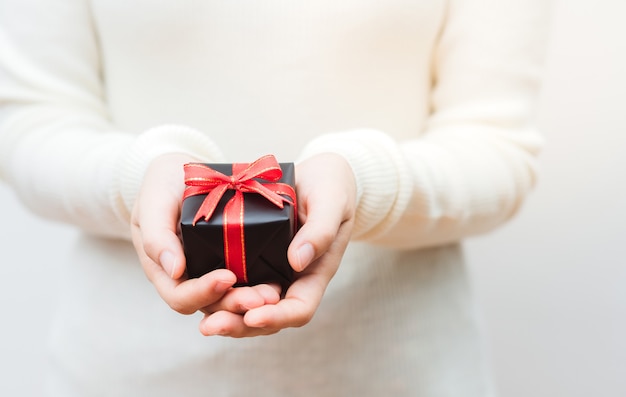 Gros plan de femme tenant un petit cadeau emballé