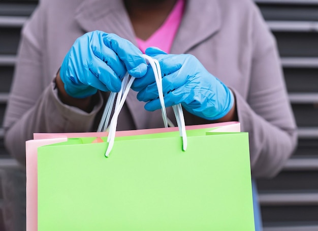 Gros plan d'une femme tenant un sac de courses avec des gants