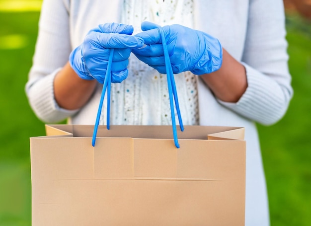 Gros plan d'une femme tenant un sac de courses avec des gants