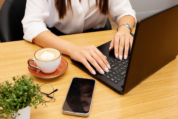 Photo gros plan femme utilisant un ordinateur portable. mains féminines tapant des notes d'écriture étudiant des langues apprentissage à distance