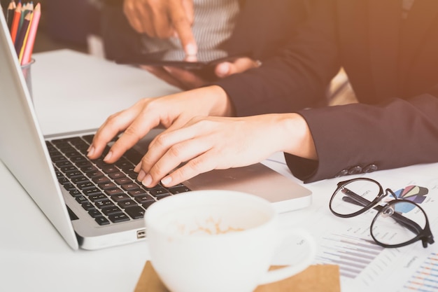 Un gros plan d'une femme utilisant un ordinateur portable sur la table.