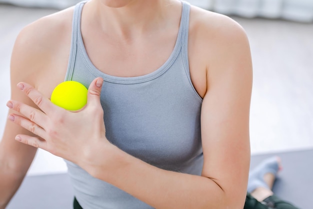 Gros plan femme utiliser des boules de massage à libération myofasciale sur l'épaule