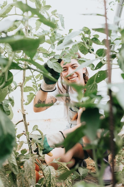 Gros plan femme vérifiant les légumes à la serre pendant une journée de travail