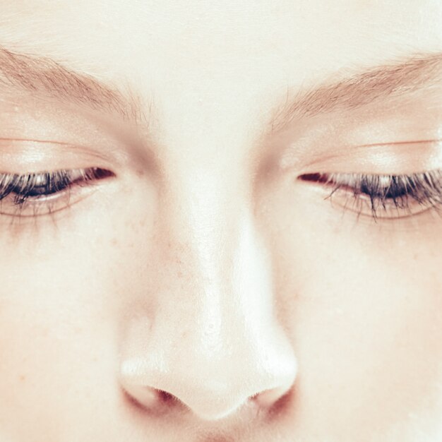 Gros plan femme visage avec une peau de beauté et de beaux cheveux blonds isolés sur blanc. Prise de vue en studio.