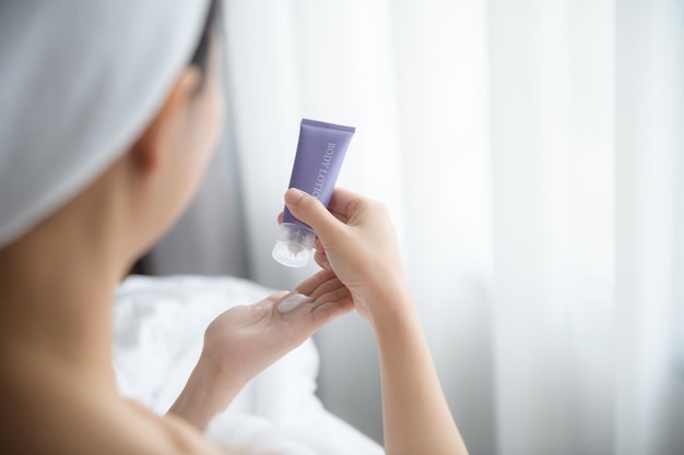 Gros plan de femmes appliquant une crème de lotion pour le corps à portée de main