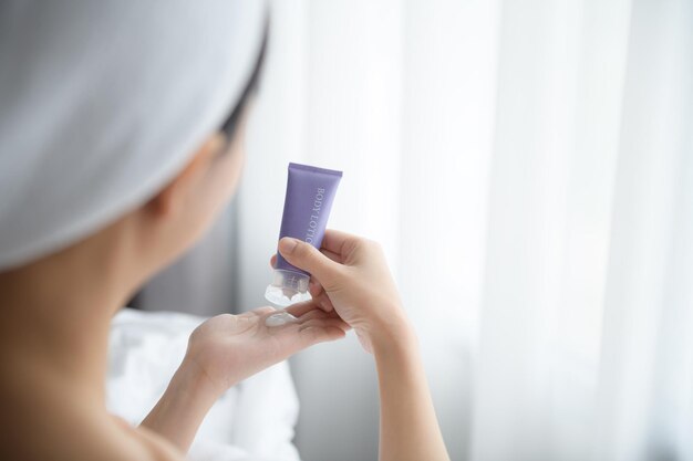 Gros plan de femmes appliquant une crème de lotion pour le corps à portée de main