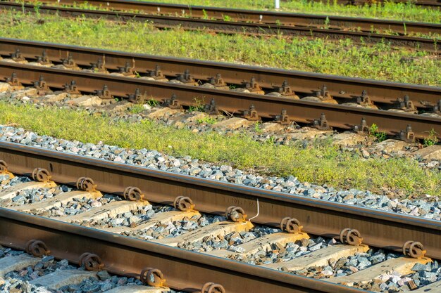 Gros plan ferroviaire pendant le coucher du soleil Vieilles traverses et rails rouillés à la station de métro