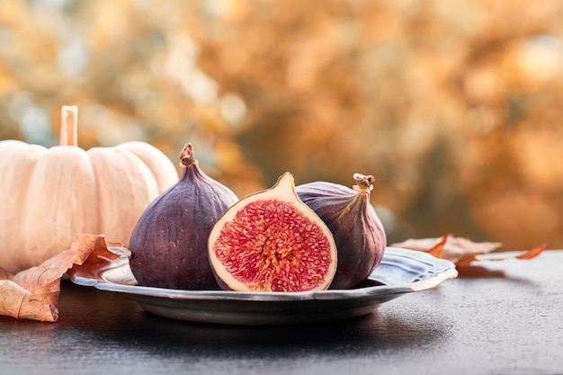 Gros plan sur des figues fraîches sur une plaque de pierre brillante sombre à l'extérieur