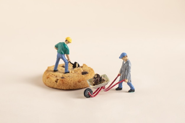 Gros plan de figurines de travail miniatures sur un cookie