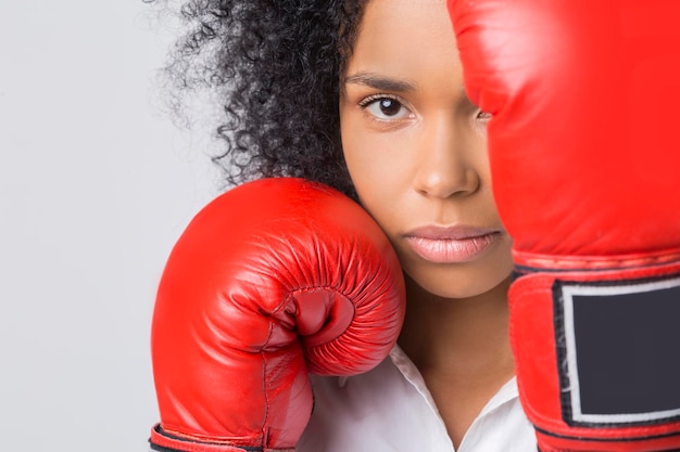 Gros plan sur une fille afro-américaine sérieuse avec des gants de boxe rouges