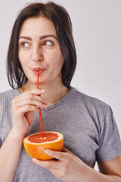 Gros plan d'une fille buvant un jus de fruit orange - concept de mode de vie sain et de personnes