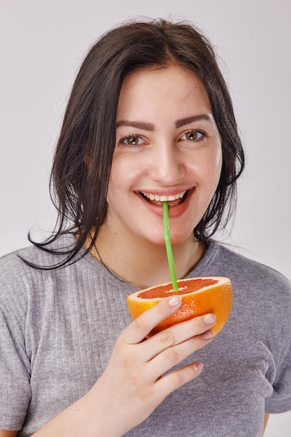 Gros plan d'une fille buvant un jus de fruit orange - concept de mode de vie sain et de personnes