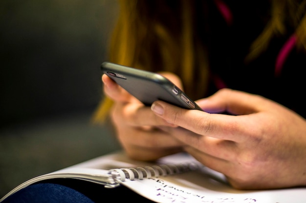 Gros plan d'une fille écrivant sur son téléphone