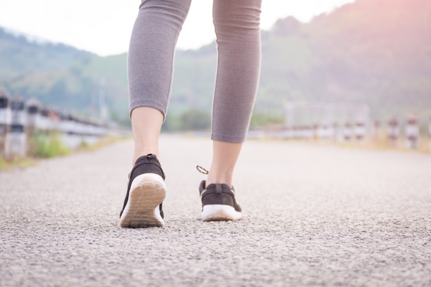 Gros plan d&#39;une fille de fitness marche sur la route