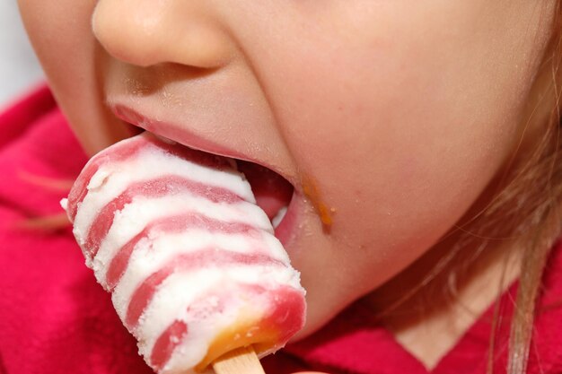 Un gros plan d'une fille qui mange de la crème glacée.