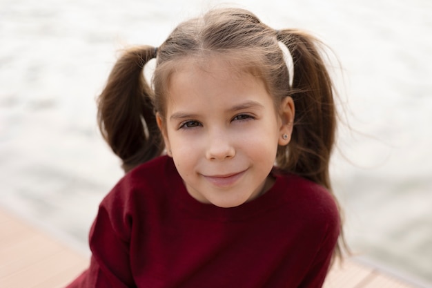 Gros plan fille souriante au bord de la mer