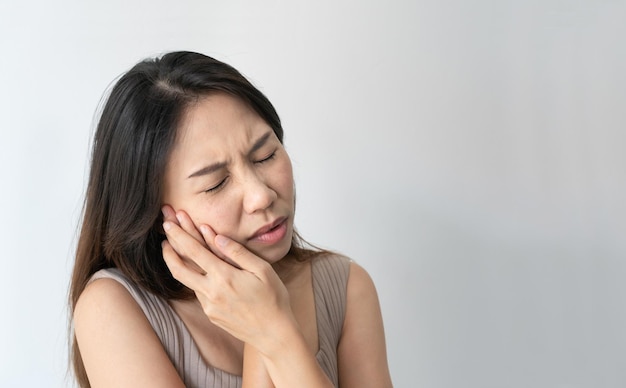 Gros plan d'une fille triste souffrant de maux de dents sur fond blanc Concept de problème de dents de santé et de soins dentaires