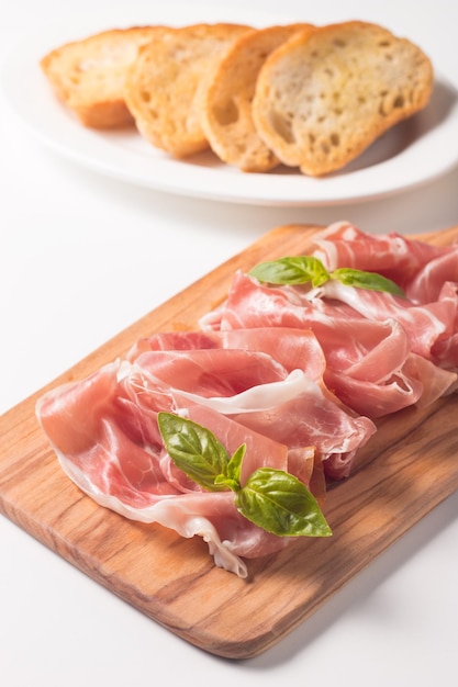 Gros plan de fines tranches de prosciutto aux olives mélangées