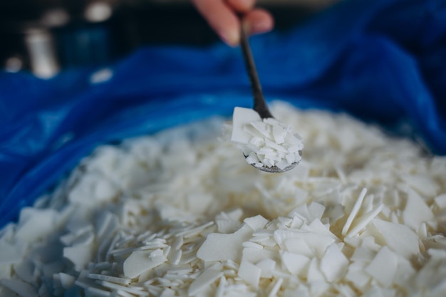 Gros plan de flocons de cire de soja blanc pour la fabrication de bougies Texture légère de flocons de cire de soja Ingrédient pour bougies maison Mode de vie écologique