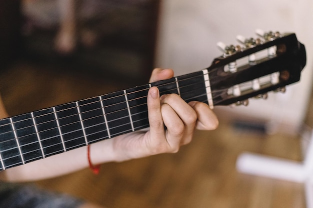 Gros plan flou d'un homme jouant de la guitare en bois