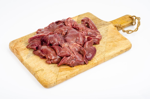 Gros plan de foies de poulet crus sur une planche à découper, ingrédients pour la cuisson, sur fond blanc. Studio photo