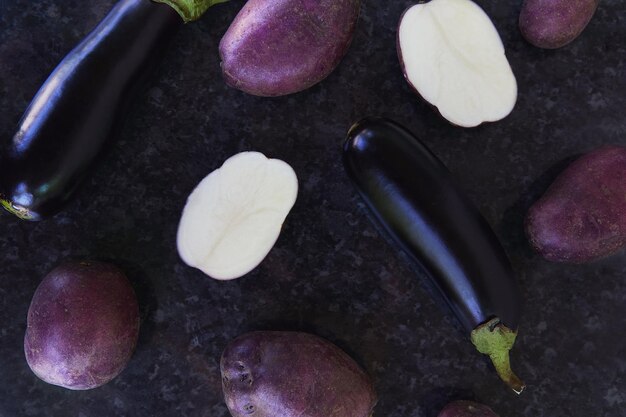 Gros plan sur fond violet de pommes de terre et d'aubergines avec des reflets