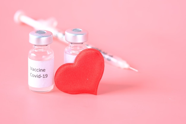 Gros Plan De La Forme De Coeur Du Vaccin Contre Le Coronavirus Et De La Seringue Sur Rose