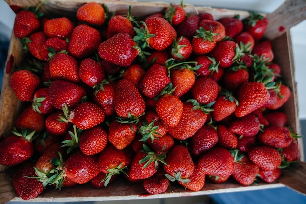 Gros plan de fraises fraîches mûres dans un récipient à vendre. Régime équilibré.