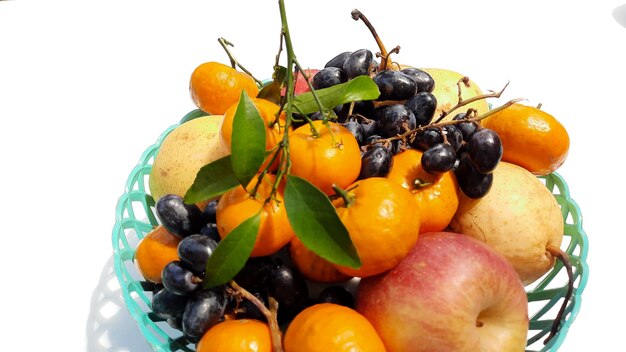 Gros plan, fruits tropicaux dans un panier vert sur fond blanc 04