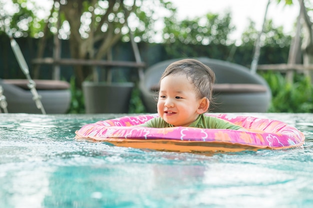 Gros plan d&#39;un garçon assis dans un bateau pour les enfants dans la piscine