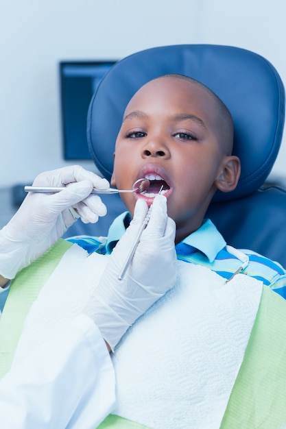 Gros plan d&#39;un garçon ayant les dents examinées