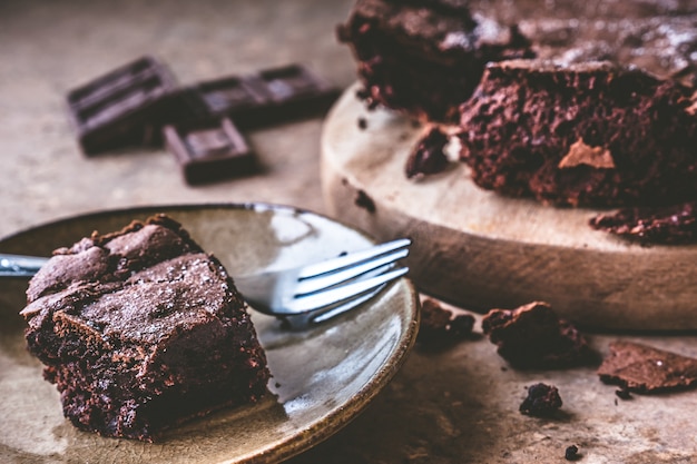 Gros plan de gâteau au chocolat sur un plat avec une fourchette.