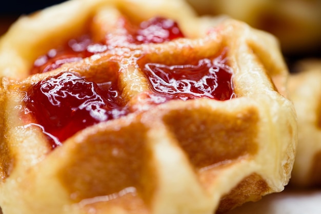 Photo gros plan sur des gaufres fraîches avec de la confiture de fraises ci-dessus