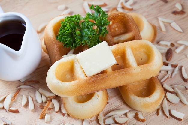 Gros Plan De Gaufres Et De Noix Avec Du Persil Et Du Fromage Sur Le Dessus Des Gaufres Sur Un Plat De Bois Pour Le Petit-déjeuner.