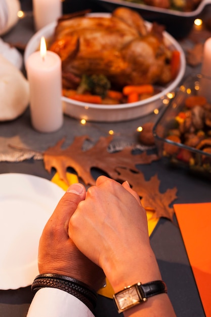 Gros plan des gens se tenant la main au dîner