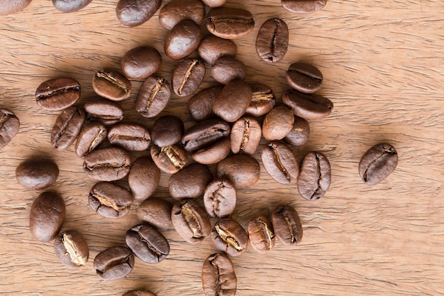 Gros plan de grains de café sur le bureau en bois