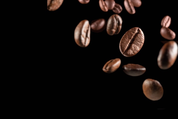 Gros plan des grains de café sur fond noir