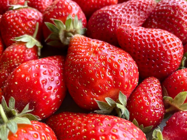 Gros plan sur un grand nombre de fraises. Fond naturel.