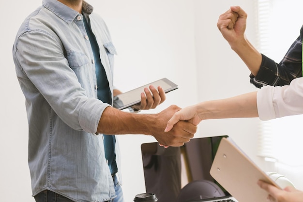 Gros plan sur un groupe, jeune entrepreneur d'équipe, poignée de main d'ingénieur avec partenariat, client après accord pour travailler ensemble sur le site, le lieu de travail, le bureau. Concept de réussite commerciale.