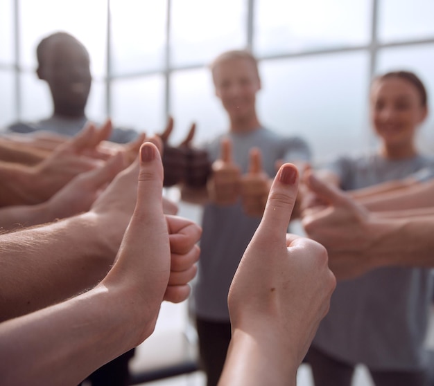 Photo gros plan groupe de jeunes montrant les pouces vers le haut