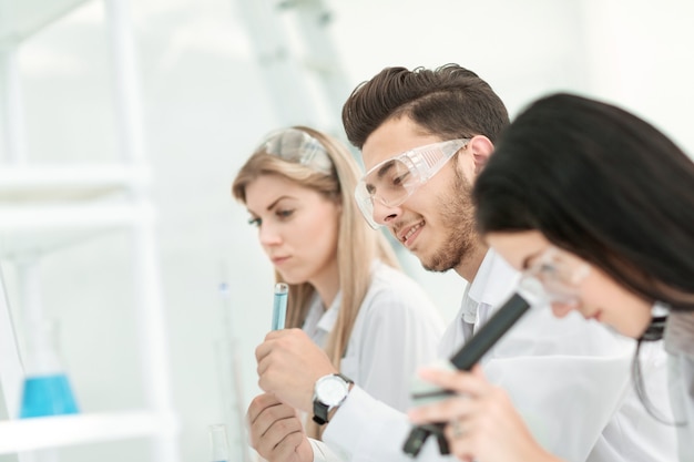 Gros plan. Un groupe de jeunes scientifiques mène des expériences en laboratoire. sciences et santé