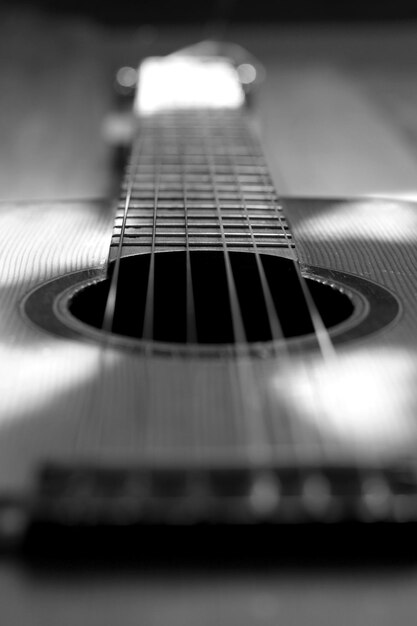 Photo gros plan d'une guitare acoustique au cou des cordes de la plaque d'affichage photo noir et blanc