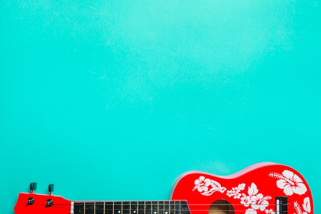 Gros plan d&#39;une guitare classique acoustique rouge sur fond turquoise