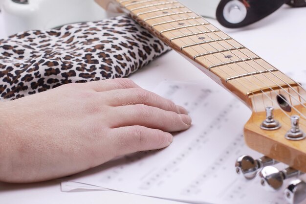 Gros plan d'un guitariste touchant des partitions isolées sur un coup