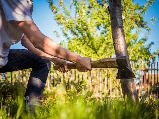 Gros plan de la hache dans la main de l&#39;homme travaillant dans le jardin