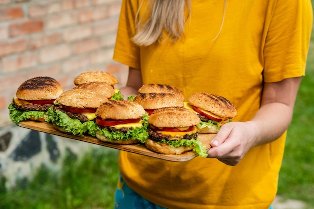 Gros plan de hamburgers faits maison à base de légumes frais sur une plaque de bois tenant des femmes