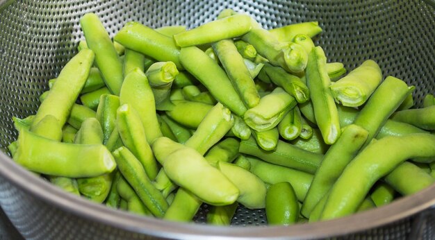 Gros plan de haricots verts dans une passoire