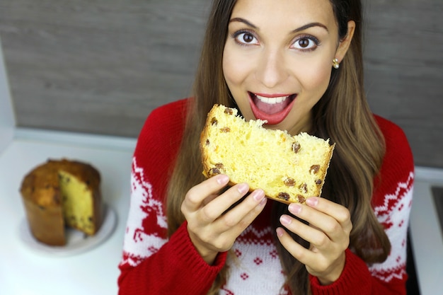 Gros plan d'en haut de la jeune femme mangeant une tranche de panettone