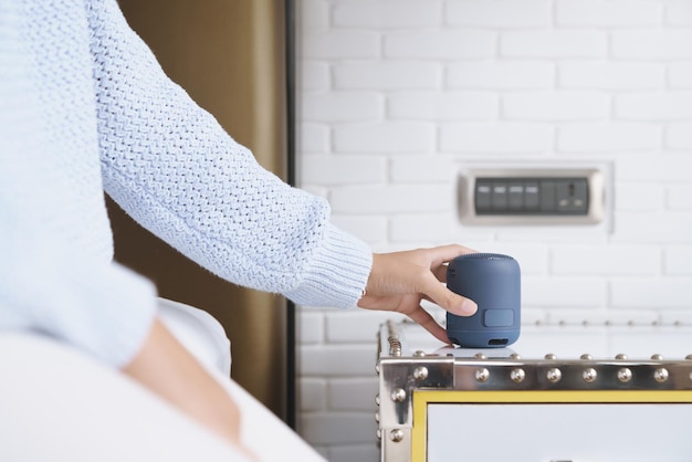 Gros plan sur un haut-parleur sans fil portable à la main sur une table, haut-parleur de nouvelle technologie facile à utiliser