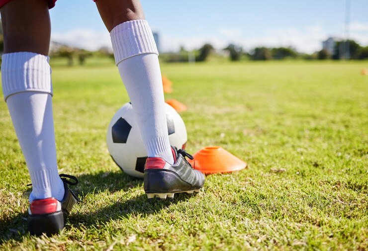 Photo gros plan sur l'herbe et l'entraînement des enfants de football pour les sports de fitness et l'équilibre pour contrôler la vitesse et le développement
